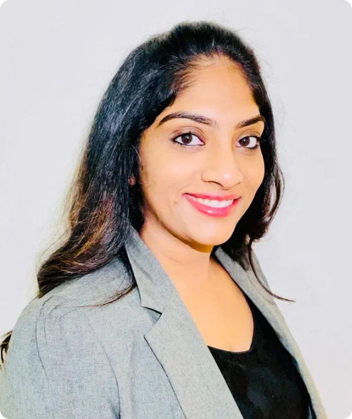 Dr. Koneru professional with long dark hair in gray blazer smiling at camera